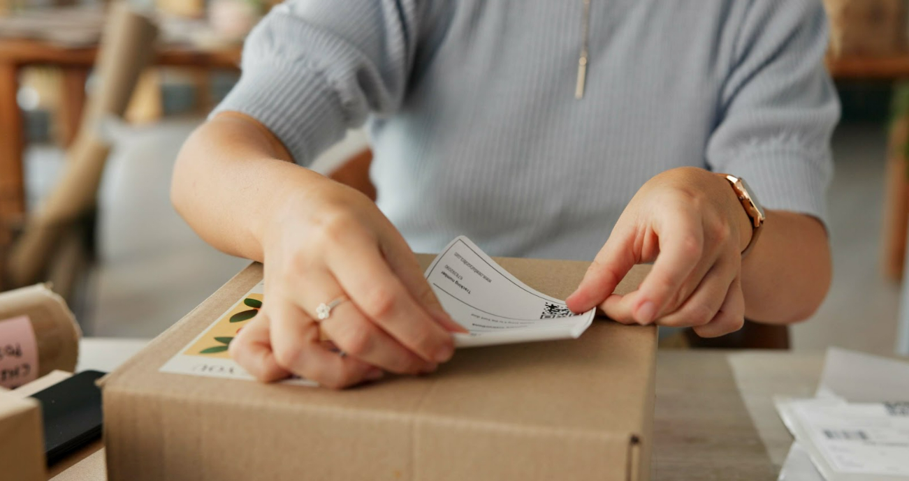 Paket wird mit Etikett beklebt