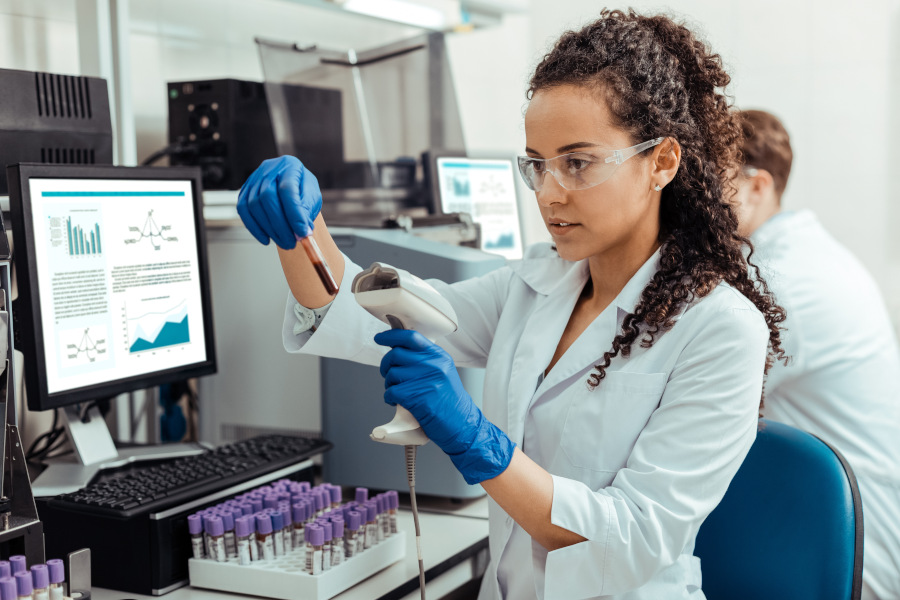Frau untersucht QR-Code Etikett im Pharma-Labor