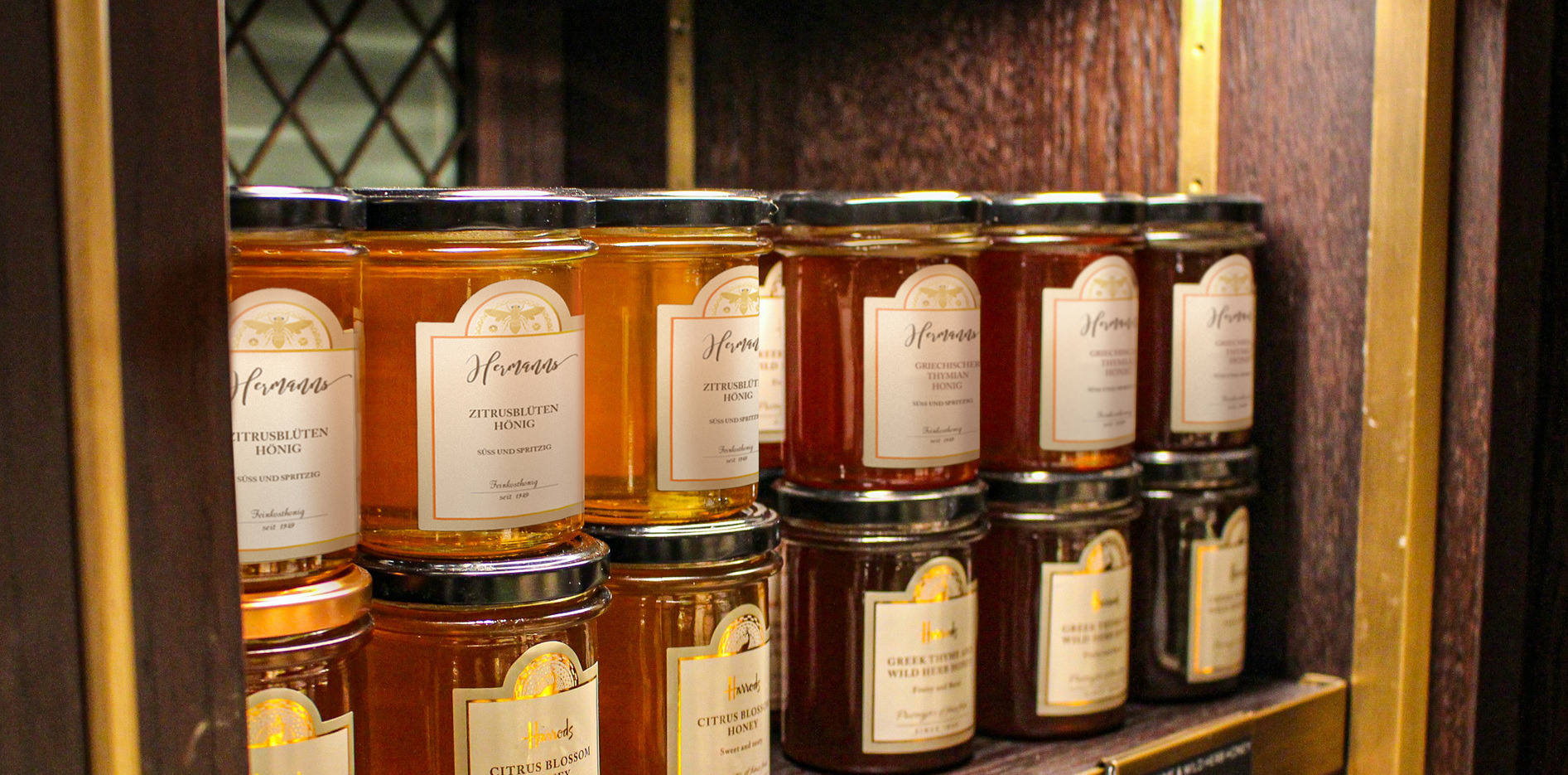 Honiggläser mit bedruckten Etiketten im Regal